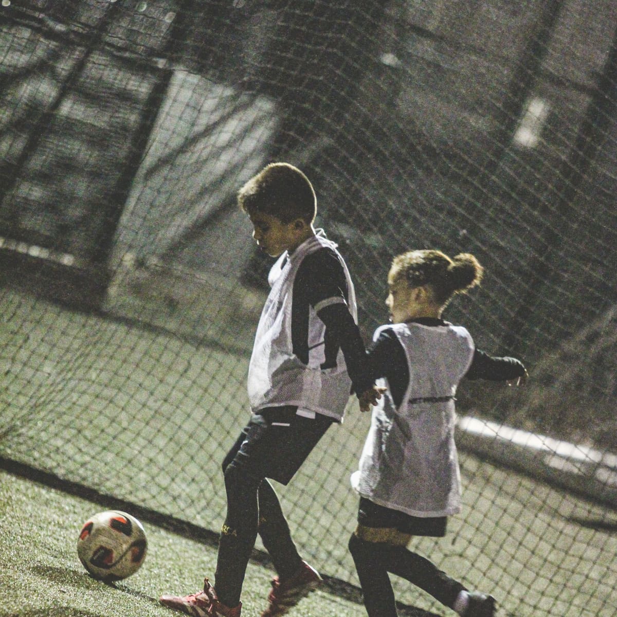 Players working with the ball beside the pitch fencing