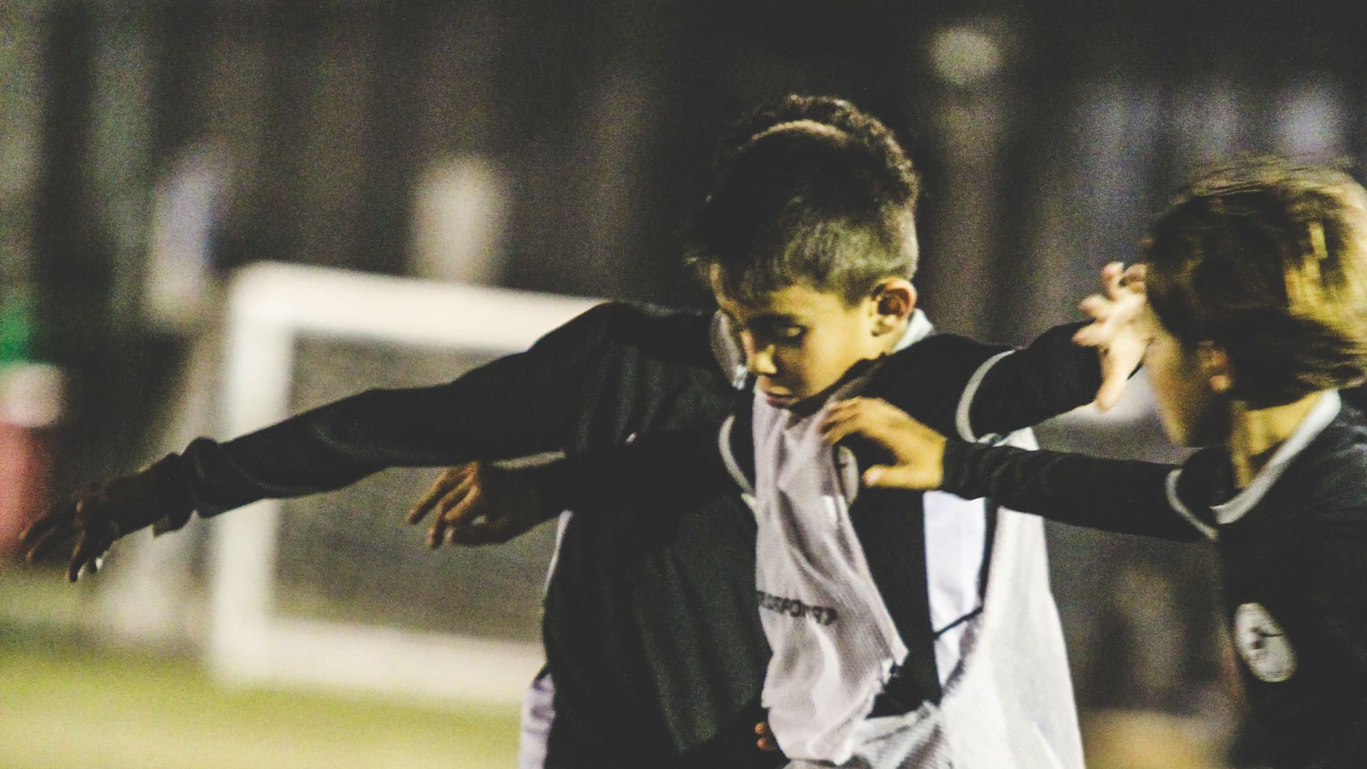 Fundamental FC players competing for the ball under floodlights