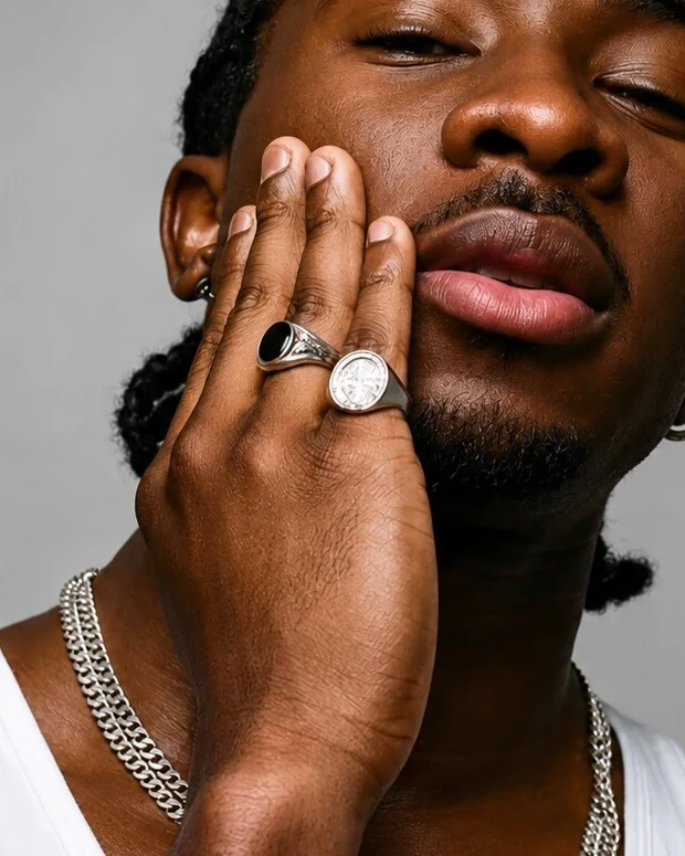 Detail of Jayo's hand with silver rings against his face