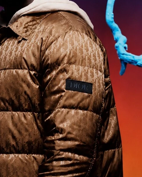 Detail of Stormzy's bronze puffer jacket sleeve and its Dior patch