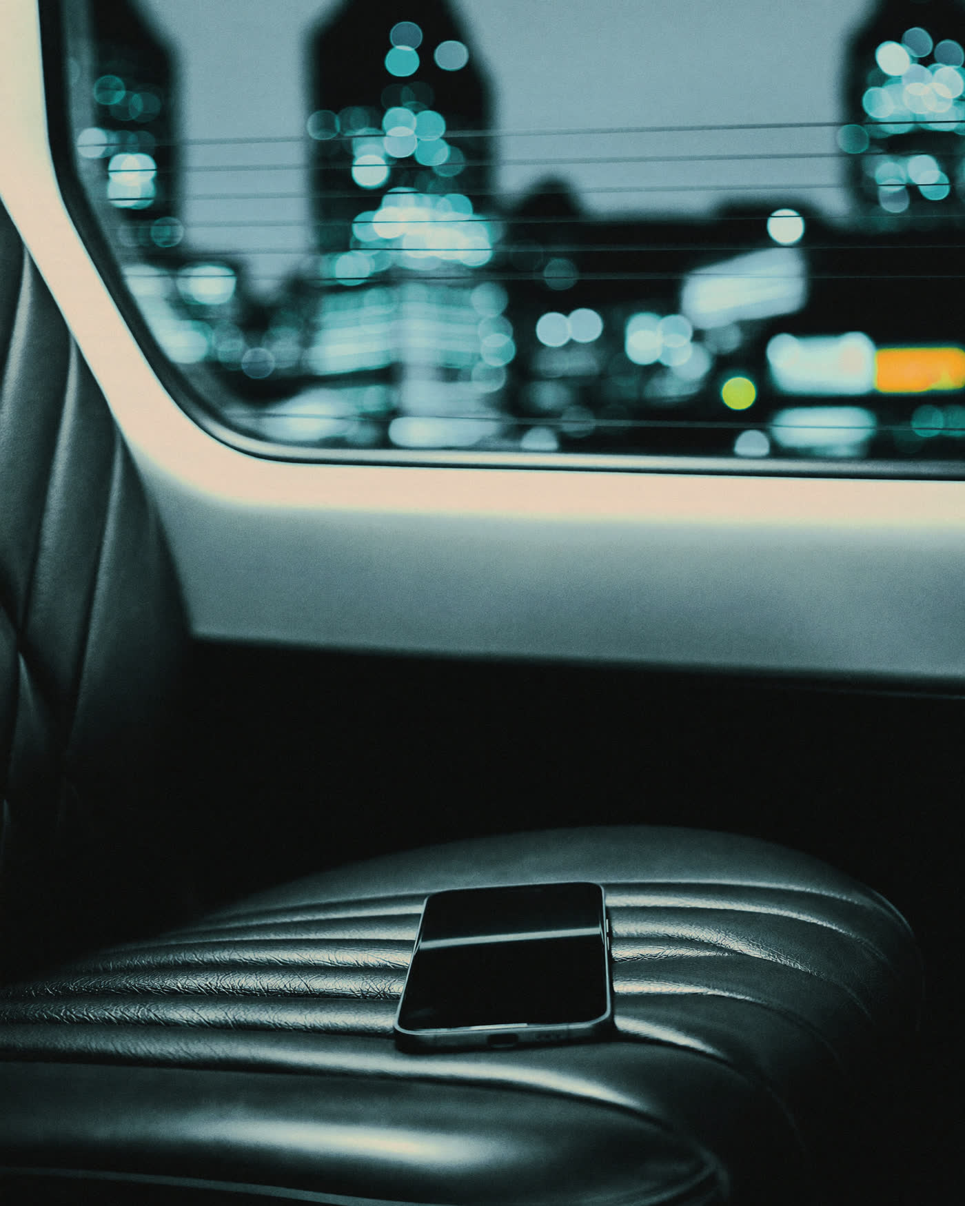 Gloved hand opening the rear door of a black executive Mercedes V-Class at night on a wet London street
