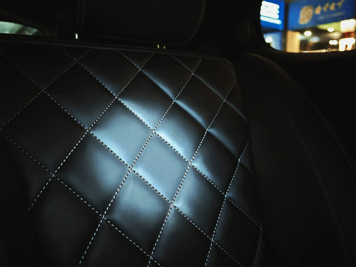Detail of the Mercedes V-Class cabin, stitched leather seating lit by cool ambient light
